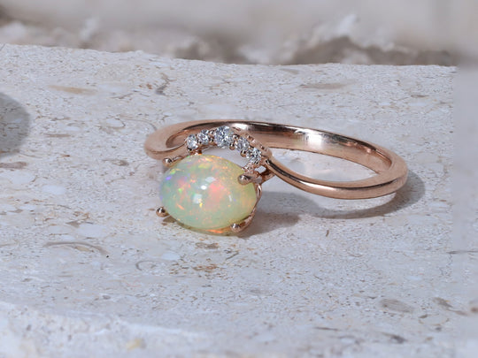 A rose gold opal and diamond engagement ring sparkles and shimmers.